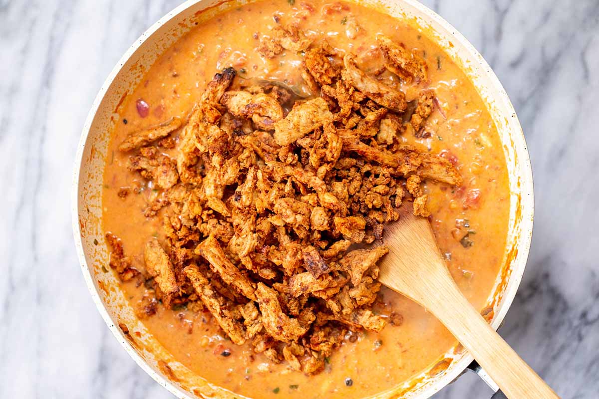 adding the cooked soy curls to the ginger curry sauce