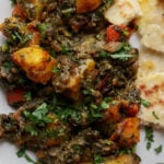 saag aloo on the plate with flatbread on the side