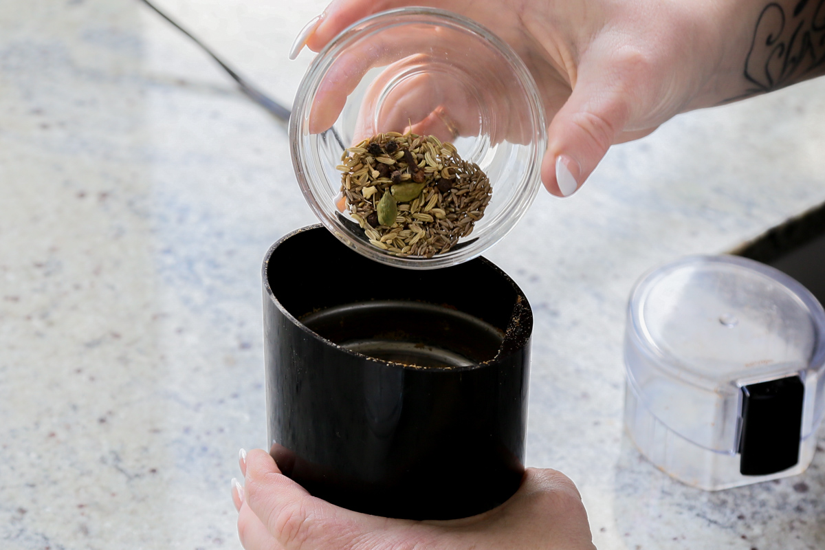 adding spices to a spice grinder
