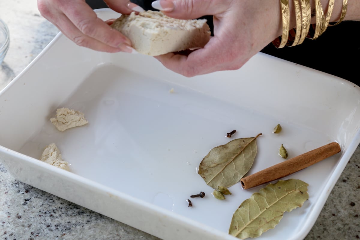 tearing tofu into the baking pan