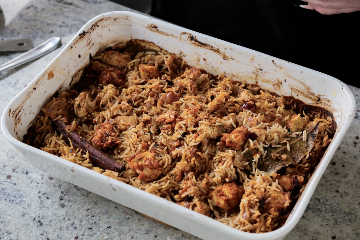 Lucknowi biryani in the pan after fluffing with a fork
