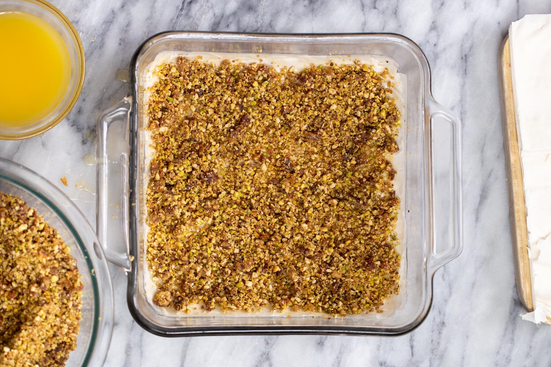 nuts and phyllo pastry being layered to make vegan baklava 