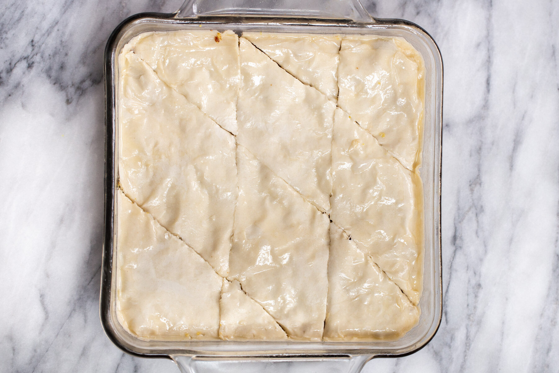 vegan baklava unbaked in a glass casserole dish 