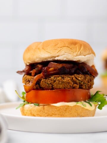 side view if vegan chickpea burger with caramelized onions and hummus