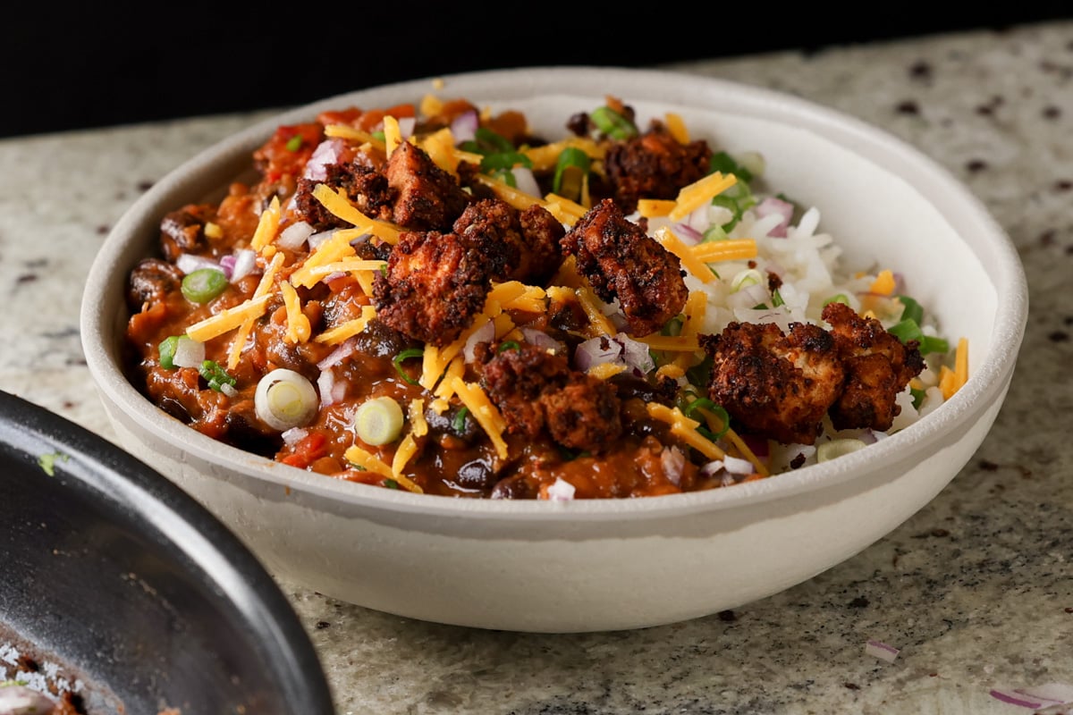 tofu chorizo burrito bowl with rice, pico de Gallo, and vegan cheese on top