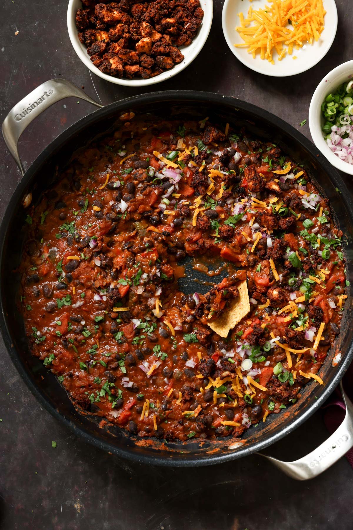 cooked beans in the pan after adding toppings and dipping a tortilla chip
