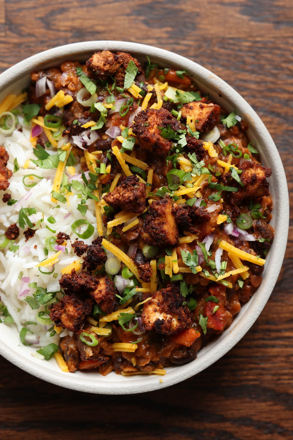 tofu chorizo burrito bowl with rice, pico de Gallo, and vegan cheese on top