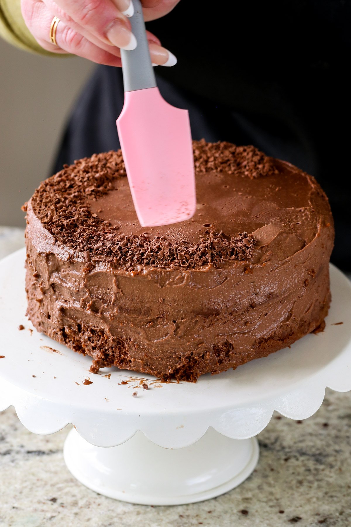 adding chocolate shavings to the vegan mocha layer cake