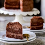 a slice of vegan mocha cake with the cake on a stand in the background