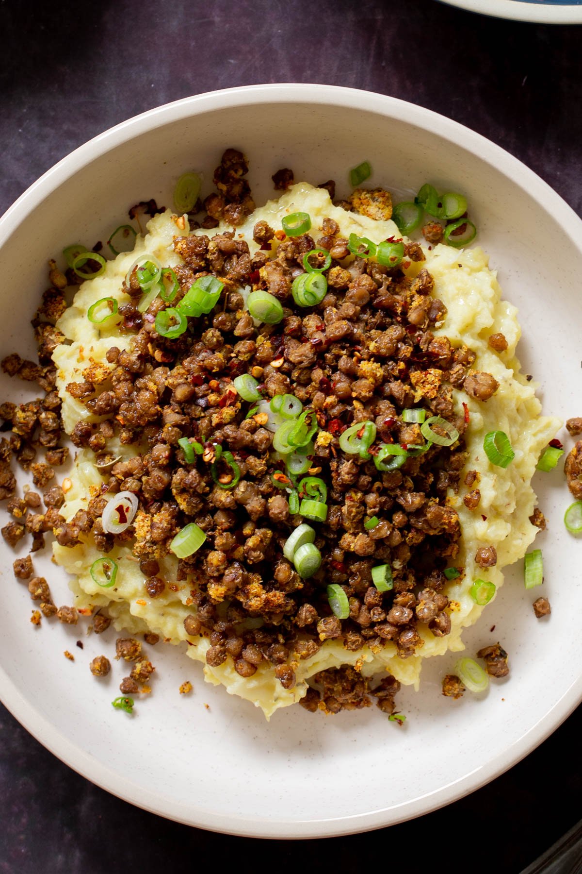 lentil mashed potatoes in a bowl with green onions on top