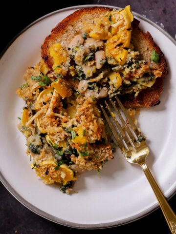 delicata squash casserole on a plate next to the casserole dish