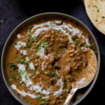 makhani dal in a serving bowl with cashew cream and cilantro on top