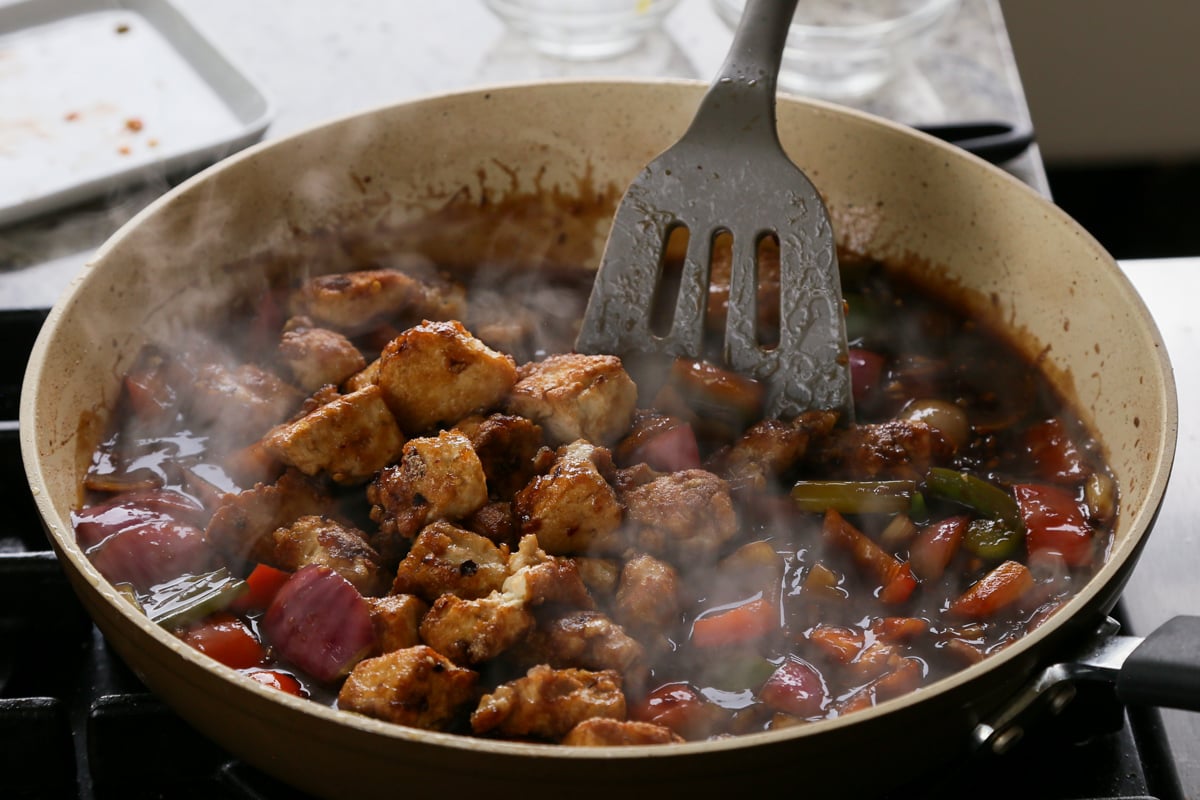 adding crispy tofu back to the pan of General Tso's sauce