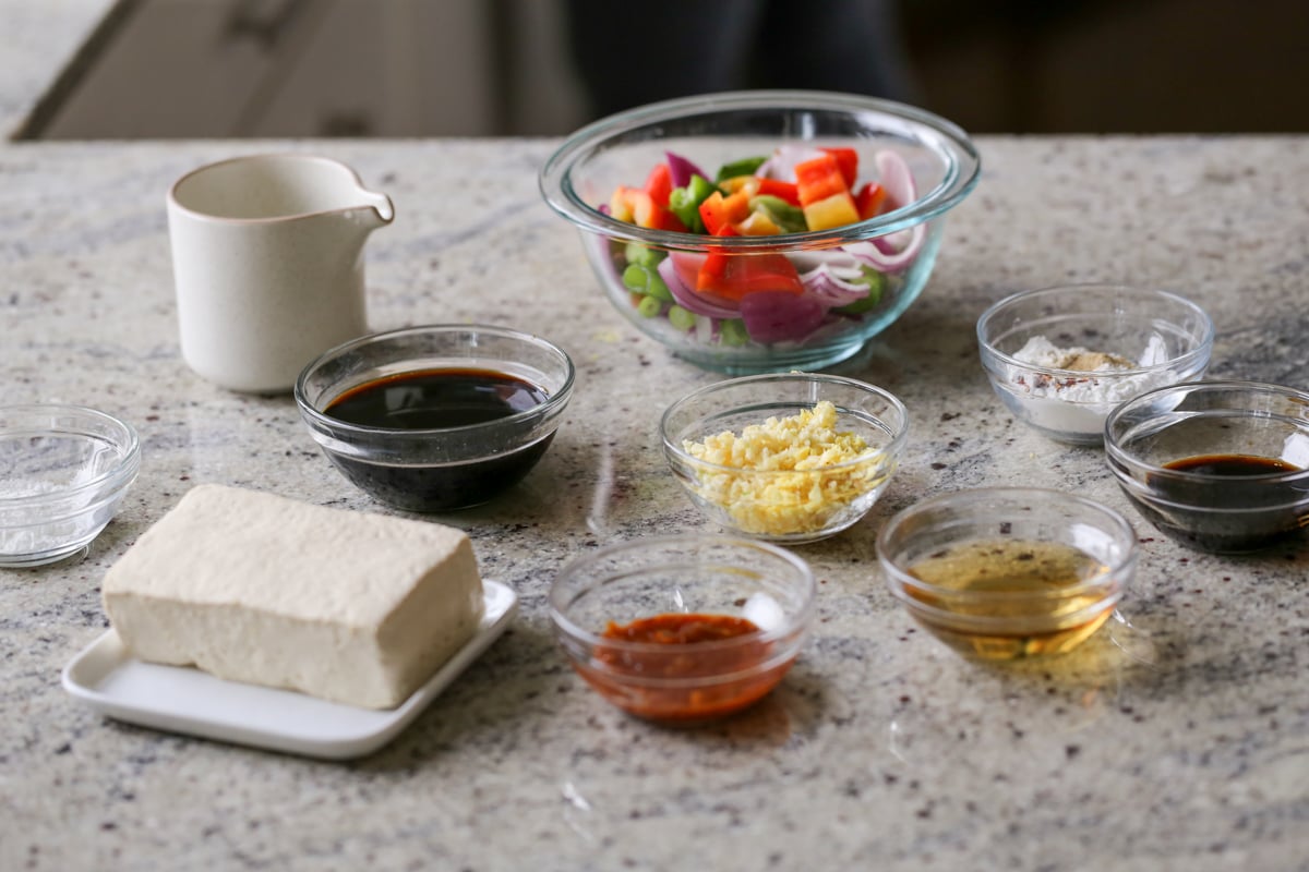 tofu, peppers, and other General Tso's tofu ingredients in bowls on a kitchen counter