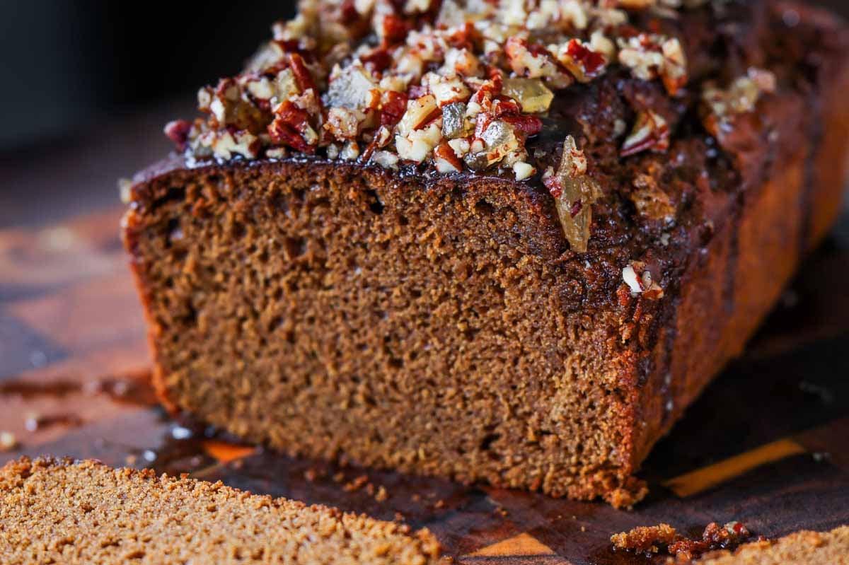 gingerbread cake on a cutting board with a slice cut out