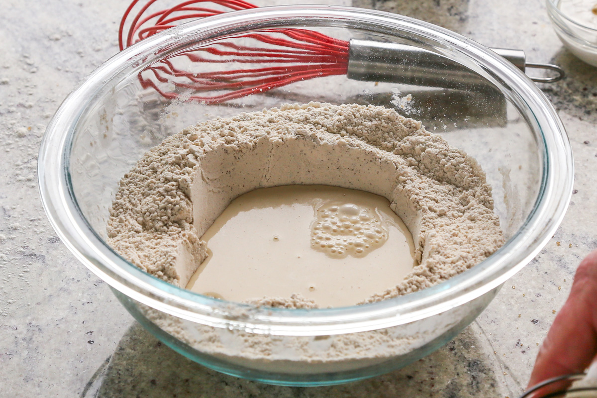 adding non-dairy milk to a well in the center of the wet ingredients