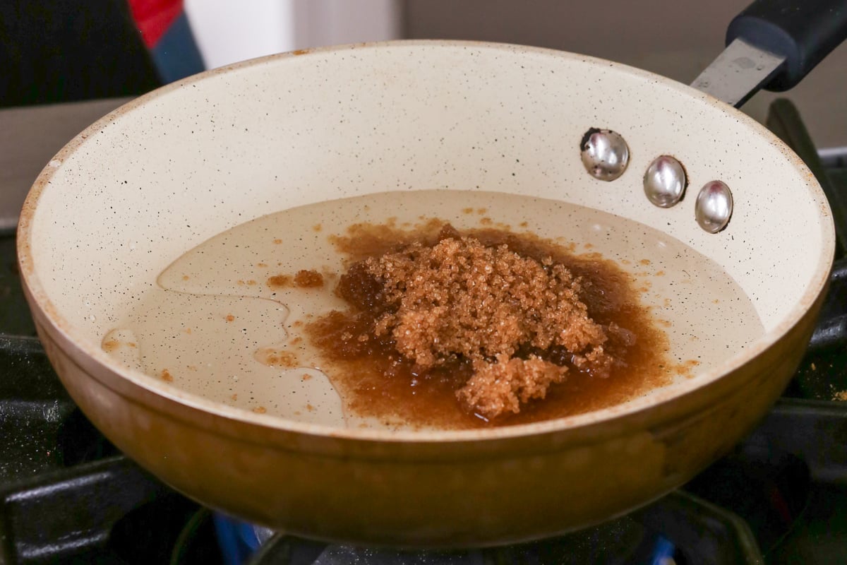 dissolving brown sugar in water in a saucepan for the ginger glaze