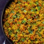Jamaican curry rice in the pan with cilantro and green onions