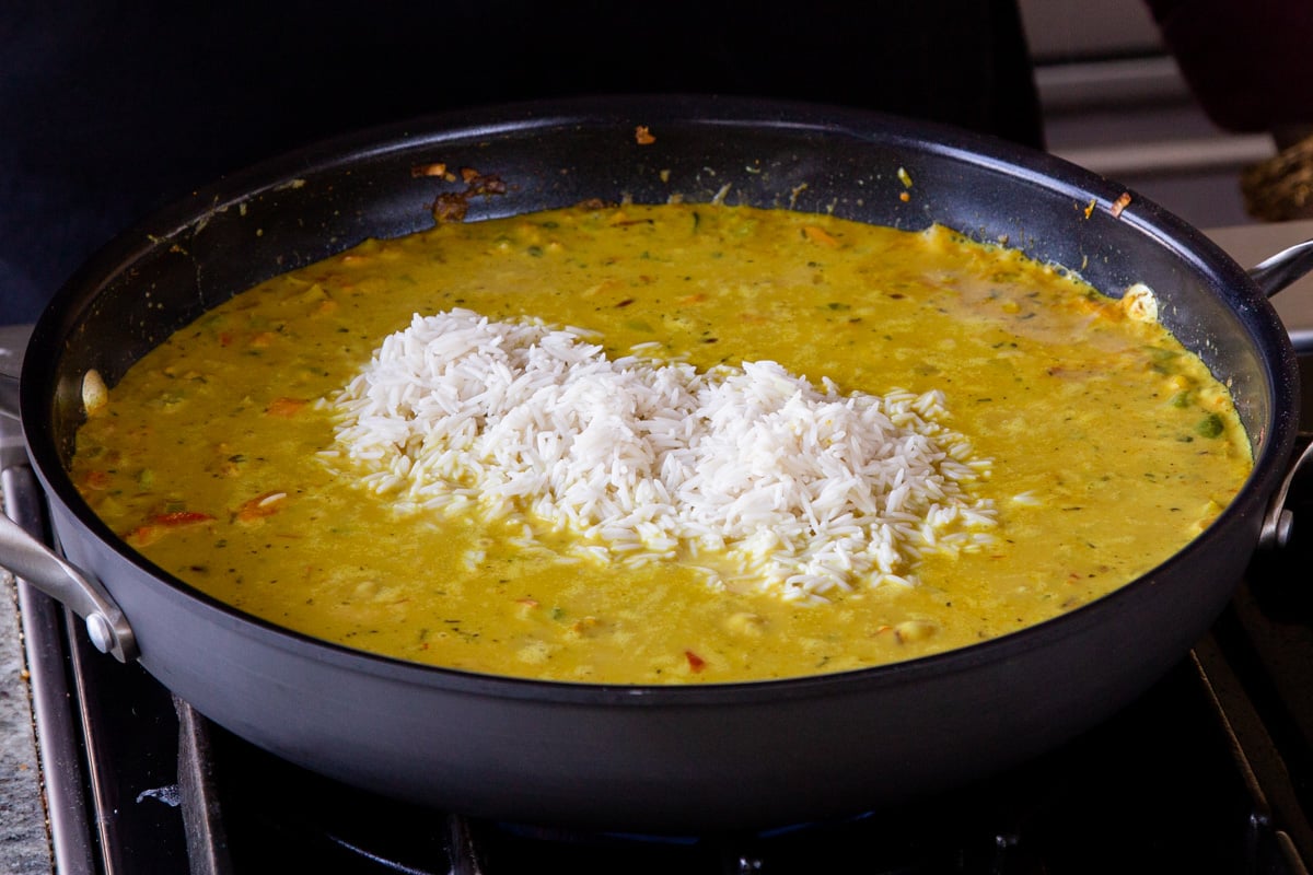 adding rice to the Jamaican curry sauce