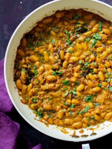 pan of spicy white bean stew with cilantro garnish