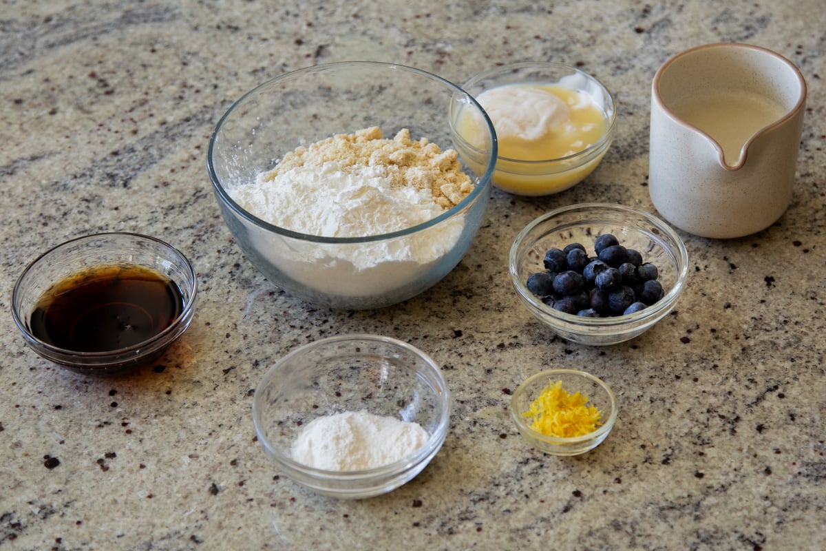 almond flour, tapioca starch, blueberries, lemon zest, and other pancake ingredients in bowls on the kitchen counter