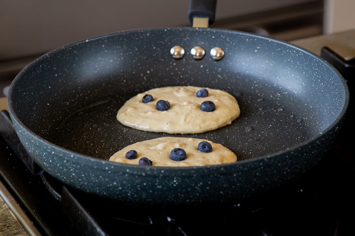 gluten-free lemon blueberry pancakes in the pan before flipping