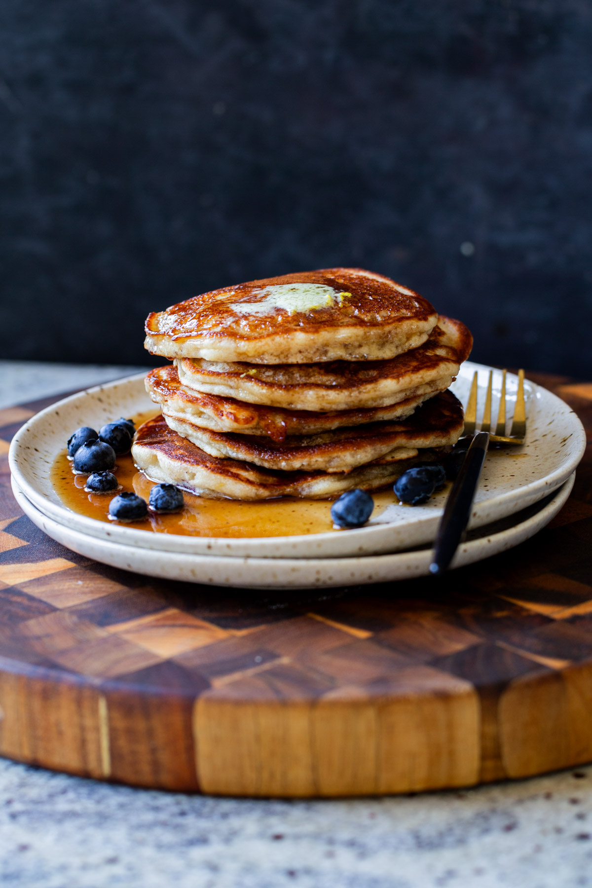 stack of gluten-free lemon blueberry pancakes on a plate with blueberries