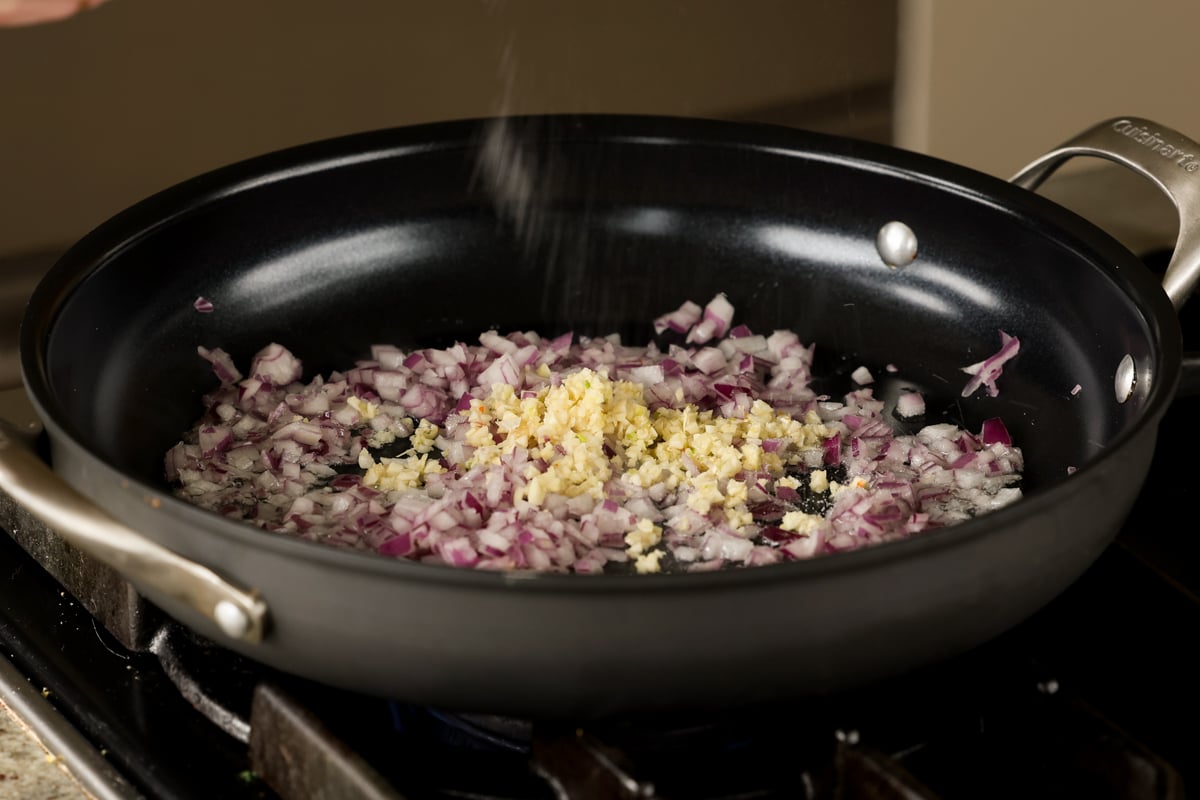 adding onion and garlic to the pan
