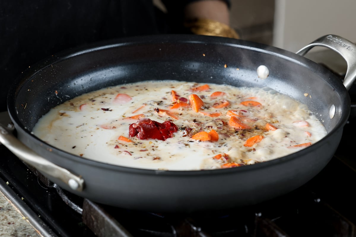 adding coconut milk and tomato paste