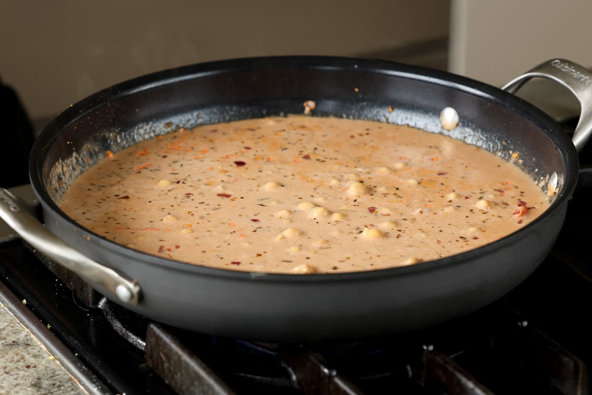 adding chickpeas to the lentil mixture in the pan
