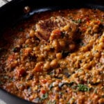 piece of toast in the pan of lentil chickpea stew