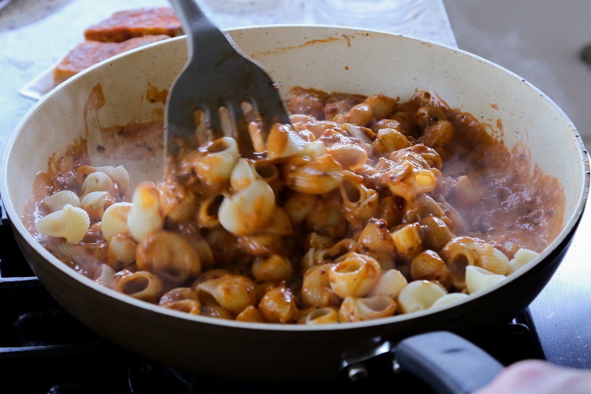 folding pasta into the sauce