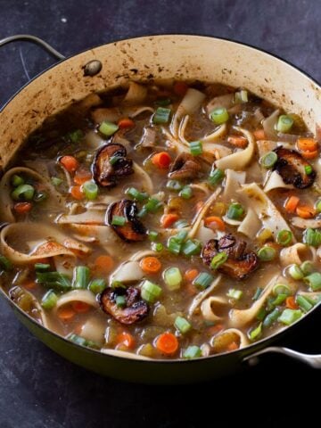 angled shot of mushroom noodle soup in the pan