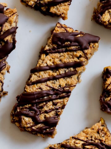 close-up of crunchy granola bars with chocolate topping on a white plate