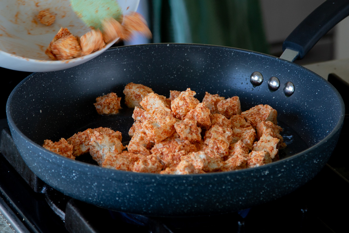 adding tofu to the pan