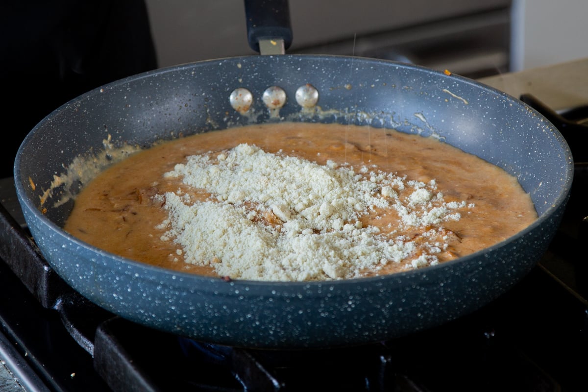 almond flour sprinkled onto the sauce in the pan