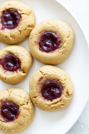 overhead shot of a plate of vegan peanut butter jelly thumbprint cookies
