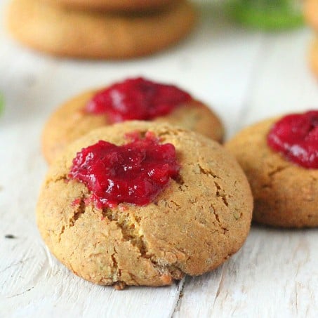 Cranberry thumbprint cookies on a wooden work surface