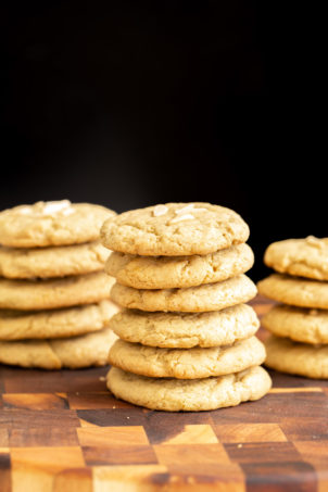 vegan pistachio cookies stacked on a wooden board