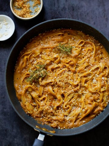 pumpkin alfredo pasta in the pan topped with the rosemary breadcrumbs