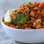 quinoa chickpea casserole in a bowl with lime wedge and green onion