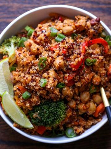 quinoa chickpea casserole in a bowl with lime wedge and green onion