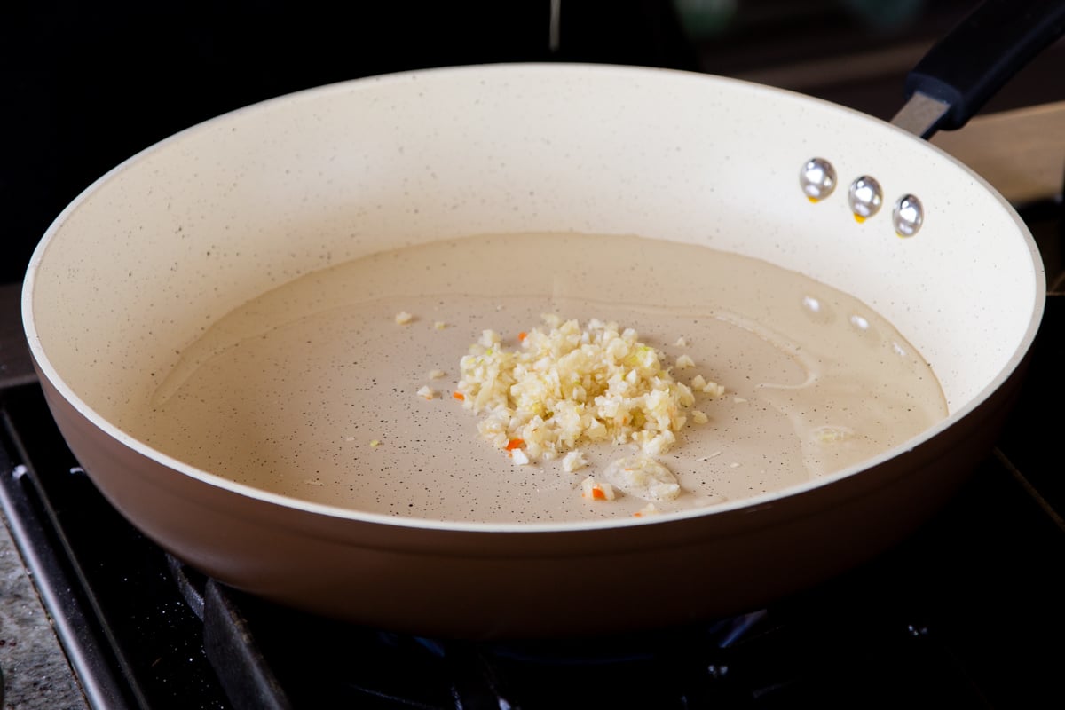adding garlic to the pan