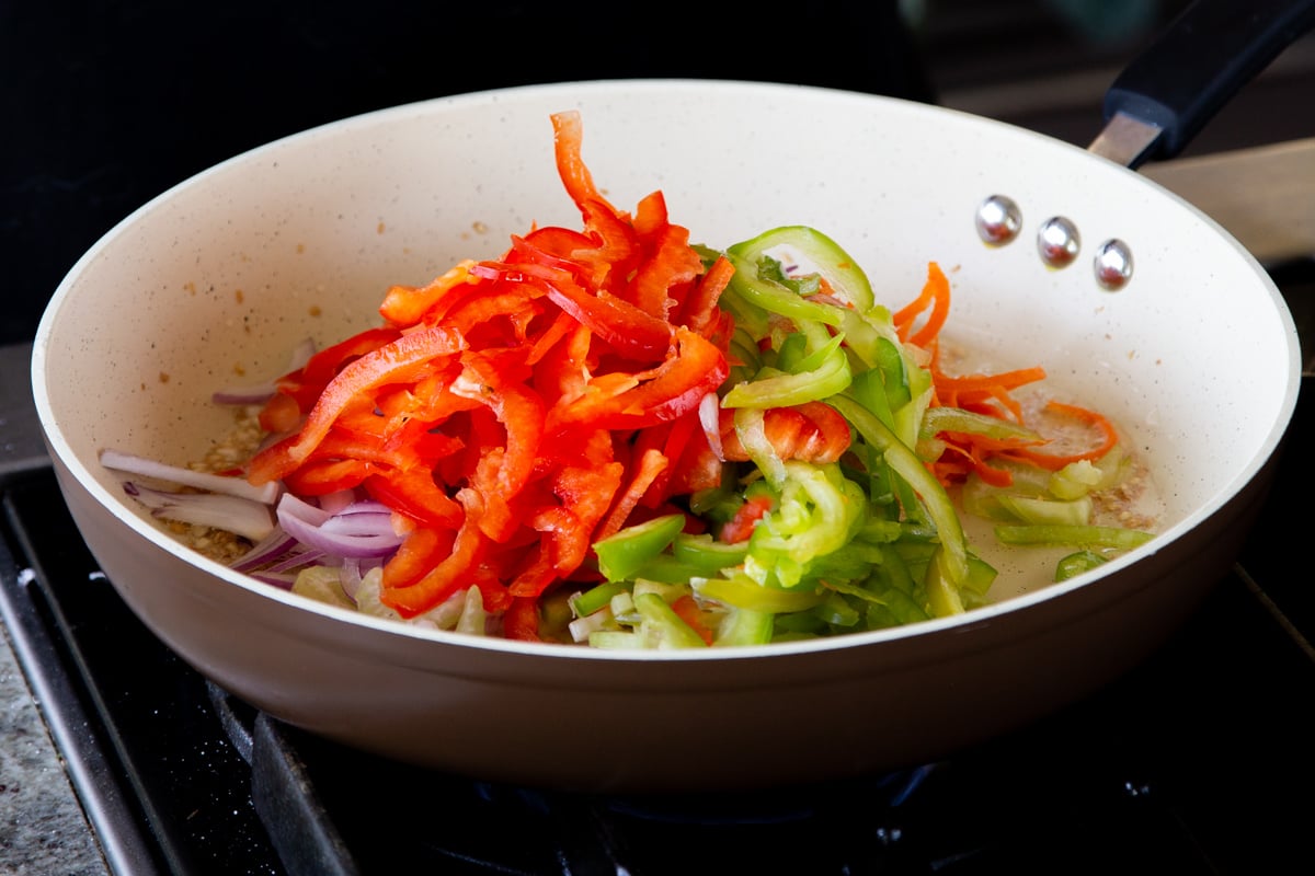 adding bell pepper to the pan 