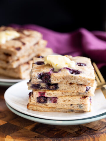 vegan sheet pan pancakes stacked on a white plate