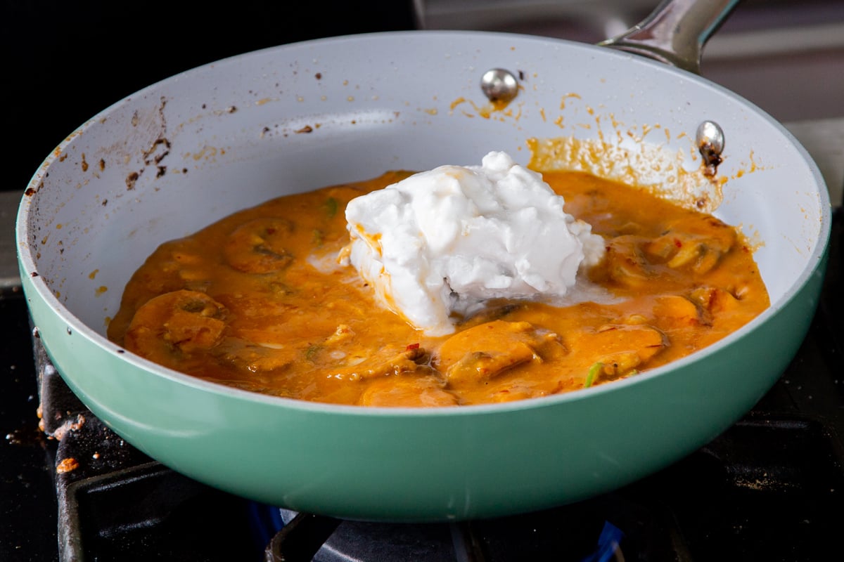 adding coconut milk to the pan