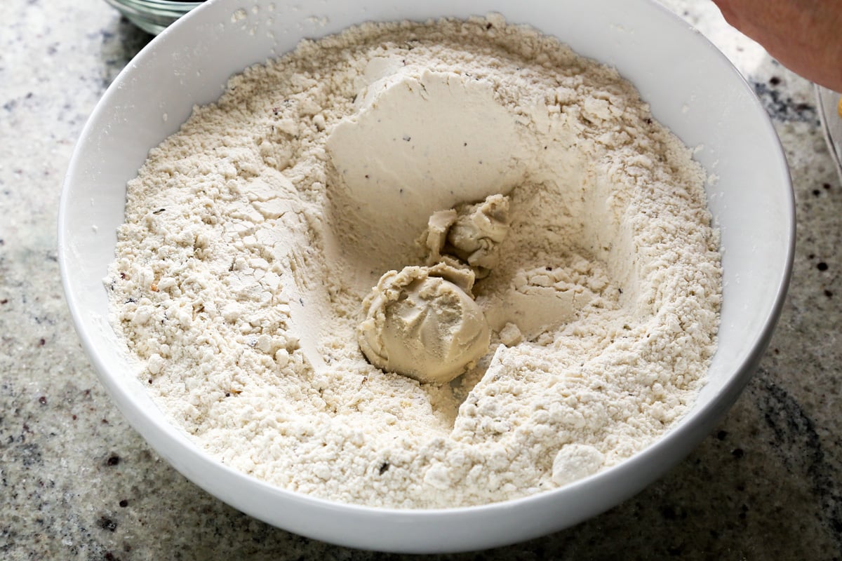 adding vegan cream cheese to the well in the dry ingredients