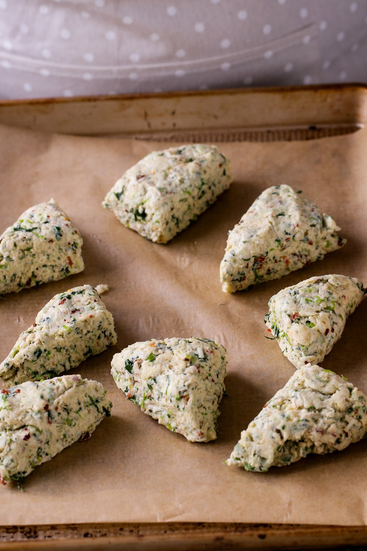 vegan spinach and cheese scones arranged on the baking sheet before baking