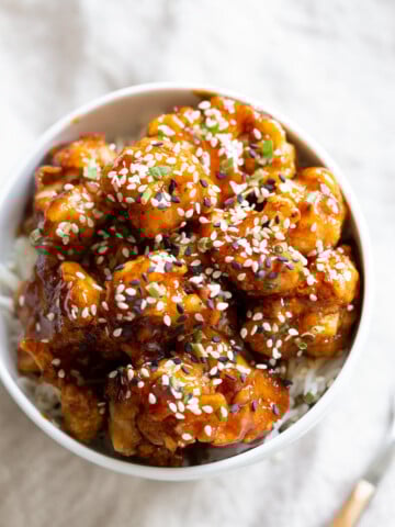 Vegan Sticky Sesame Cauliflower over rice in a white bowl
