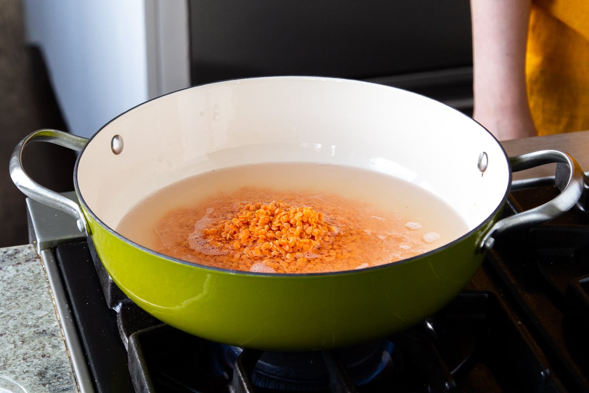 red lentils and water in a green skillet